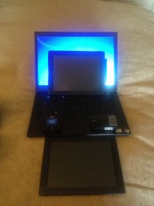a laptop and tablet on a bed