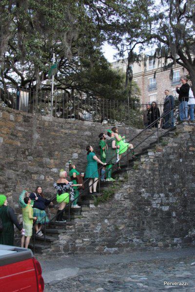 a group of people in green dresses on stairs